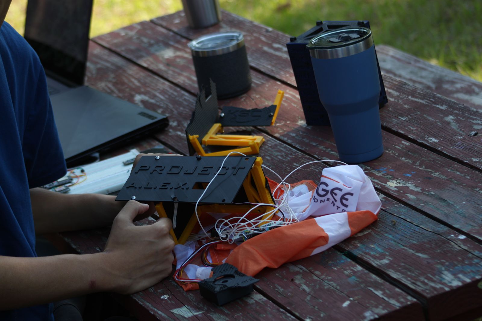 Team inspecting the recovered payload and parachute on a table